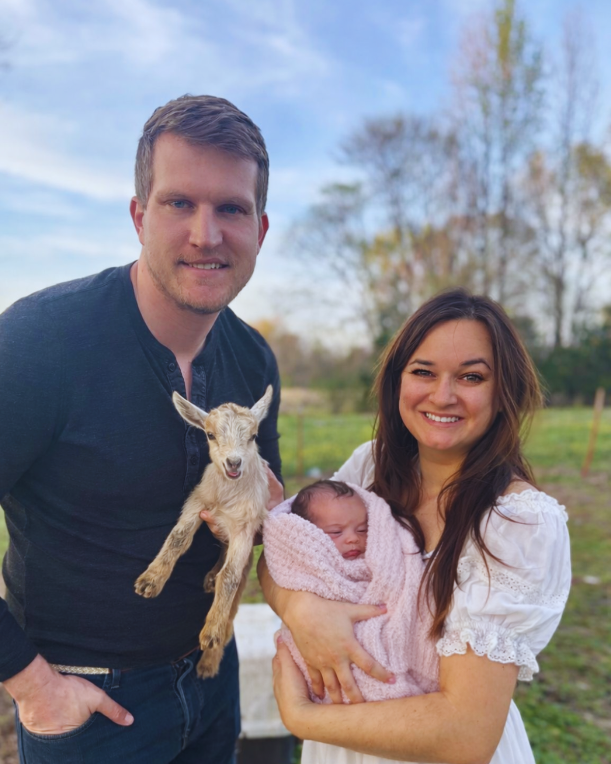 David, Kayla, and baby Savannah on the farm with a baby goat